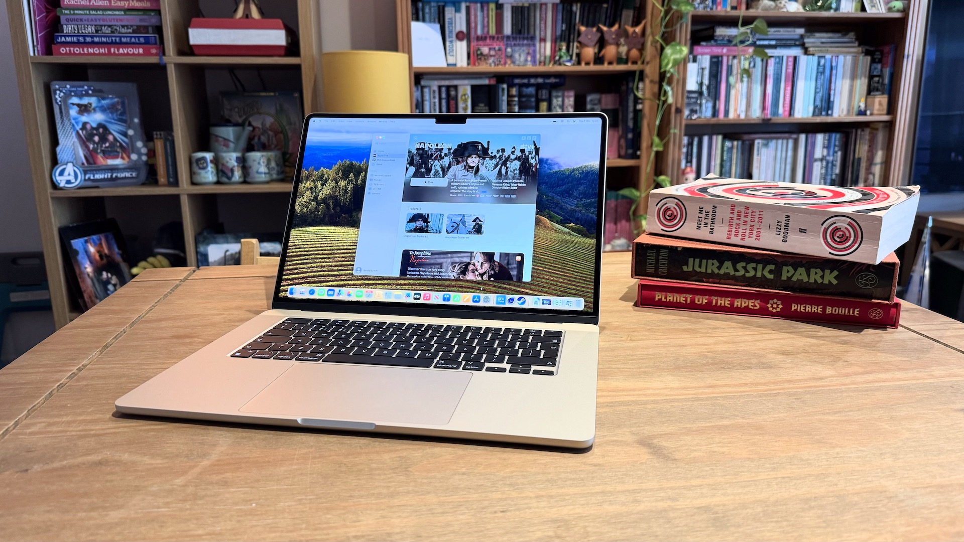 The 2024 MacBook Air M3 on a wooden table in front of a bookshelf.