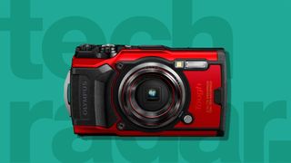 The Olympus Tough TG-6, one of the best point and shoot cameras, on a green background