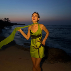 woman wearing green mini dress with neck scarf