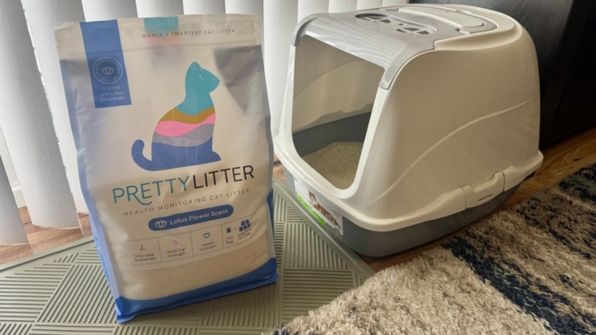 A bag of Pretty Litter, one of the best cat litters, next to a litter box