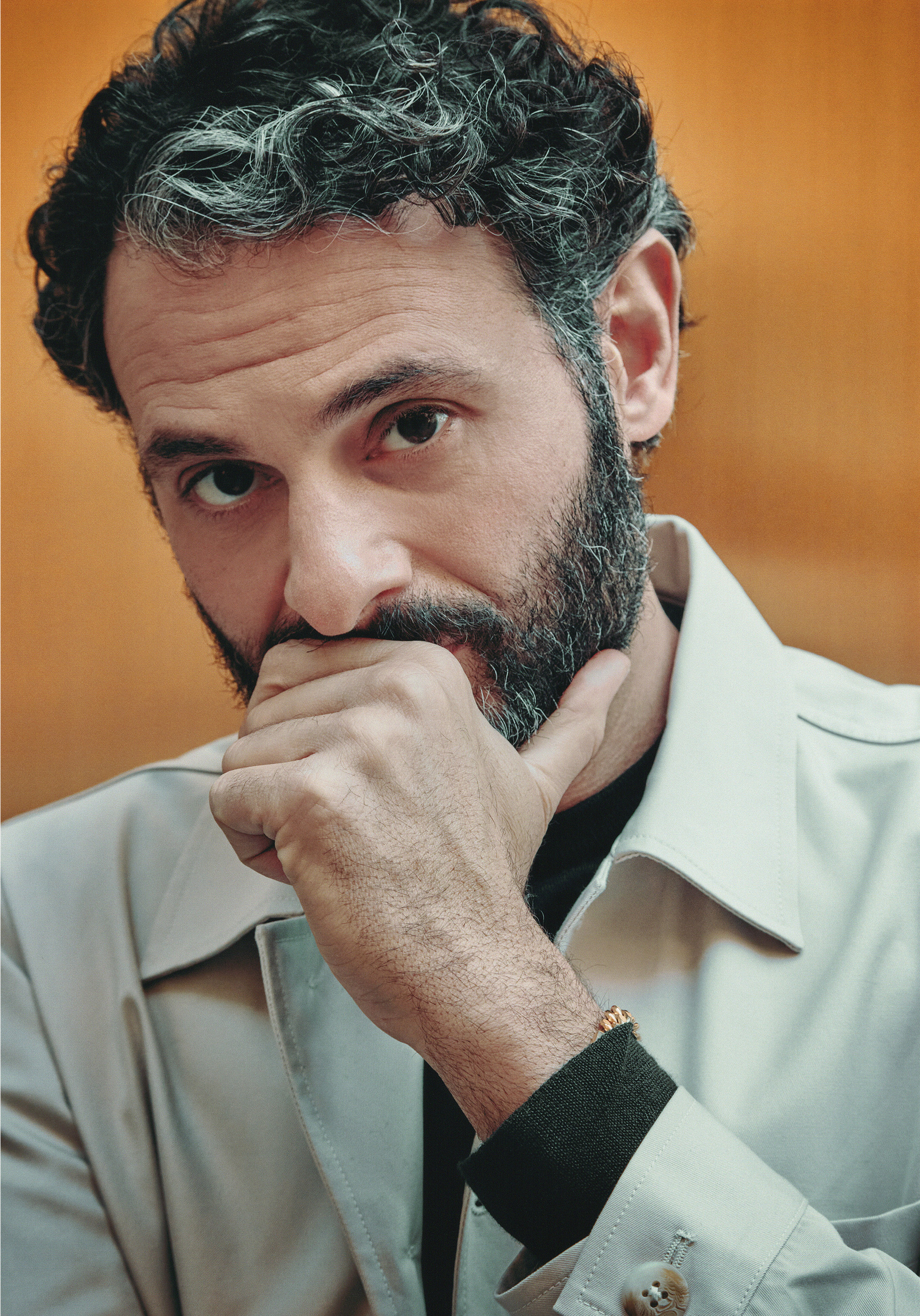 actor Arian Moayed poses in a profile shot of himself with his hand grazing his mouth and chin