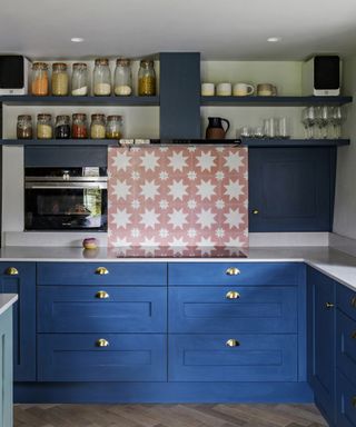 A backsplash idea for kitchens with blue cabinets and pink tiles