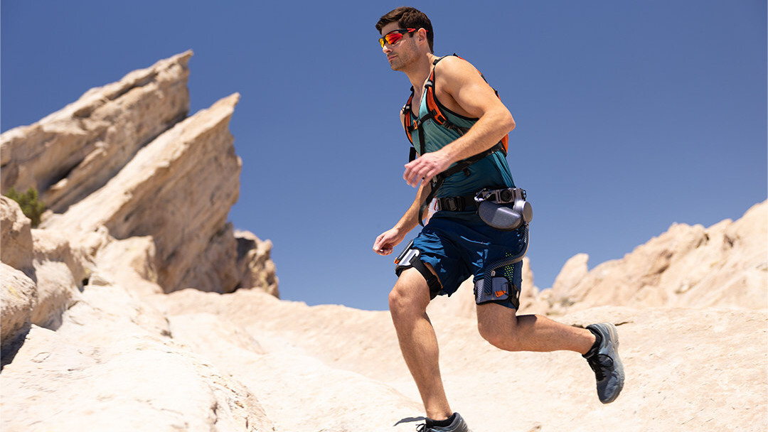 A man running through a desert with an Ascentiz exoskeleton system