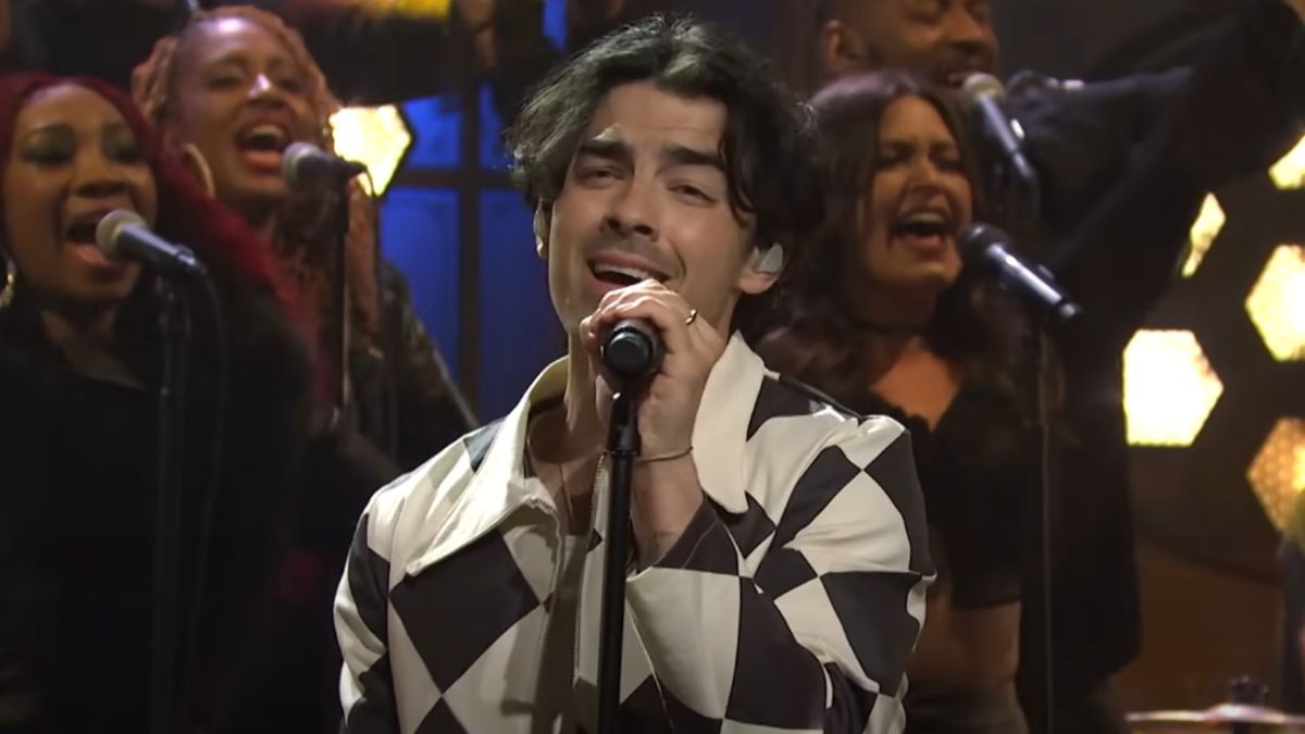 A screenshot of Joe Jonas singing into a microphone on Saturday Night Live.