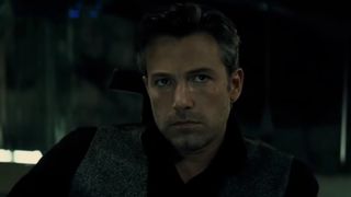 Ben Affleck looking serious as Bruce Wayne, in a dark shirt and gray vest in Batman v Superman: Dawn of Justice. 