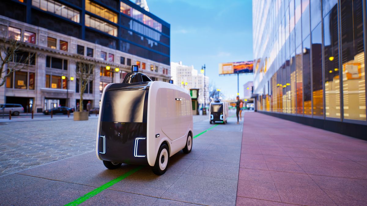 An autonomous robot driving down a street to make a delivery. Decorative: the shot is a close-up on the robot, which has four wheels and a sensor on top.