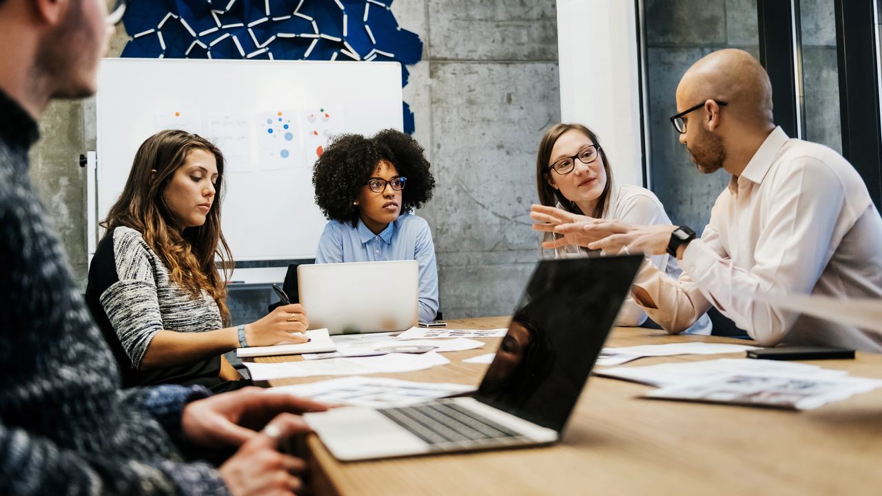 A group of business executives sit around a conference table for a planning session.