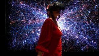 Woman wearing VR headset in front of light display