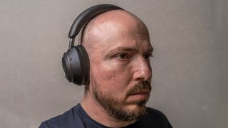 Man wearing Anker Soundcore Space One Pro headphones with ear cup and cushion in view.