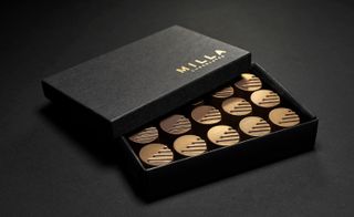 Half open box of Milla Chocolates Large Bon Bon photographed against a black background