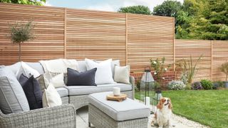 modern cedar slatted fence in garden with lawn and patio area