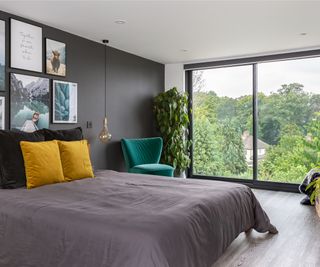 dormer loft bedroom with large sliding doors, grey wall and grey bedding with yellow cushions