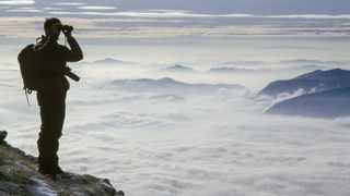 hiker looking through binoculars