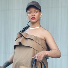 Rihanna wears a brown Saint Laurent dress with Puma Speedcats and a Schiaparelli bag.