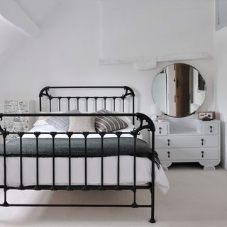bedroom with white wall and metal bed