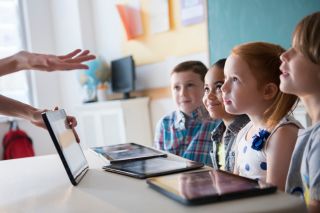 Social emotional learning lesson with kids and teacher and tablet computers