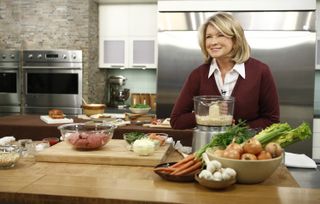 martha stewart smiles in front of a kitchen counter with various vegetables in a shot from the martha stewart show