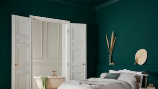 A bedroom with a green wall painted with Graham & Brown paint