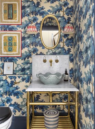 Powder room with blue wallpaper and gold fittings