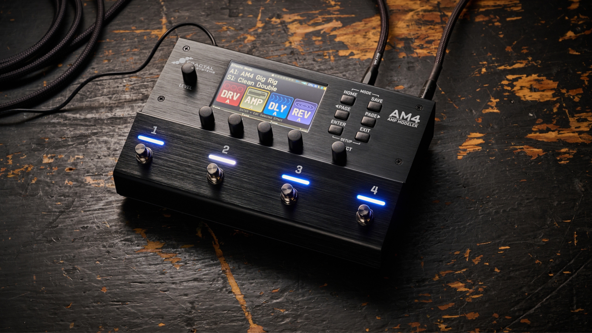 A Fractal Audio AM4 multi-effects pedal on dark wooden floor
