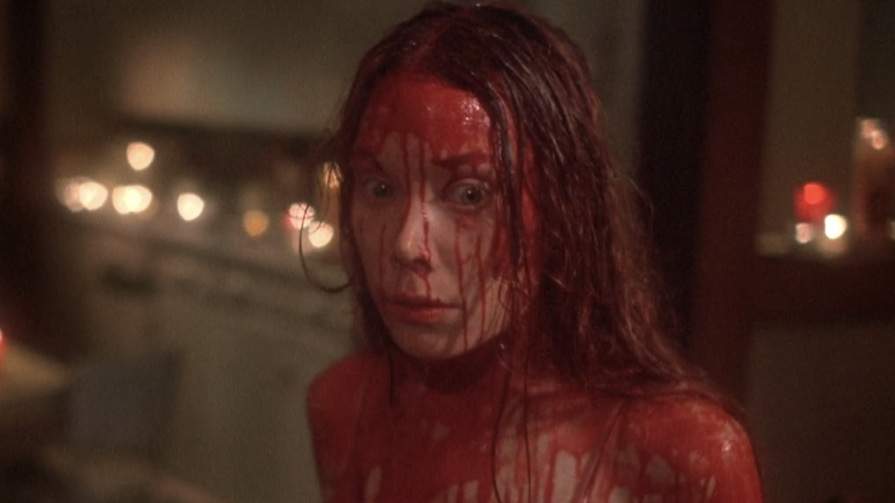 Screenshot of bloody Carrie back at home surrounded by candles in 1976's Carrie