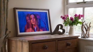 Vieunite Textura digital canvas on a wooden table by a window displaying a vivid portrait