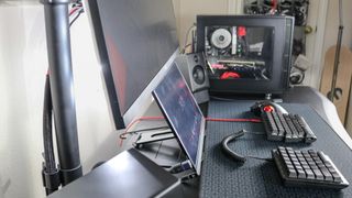 A portable monitor sitting on a laptop stand underneath an ultrawide monitor
