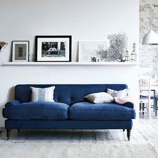 room with blue sofa and white wall