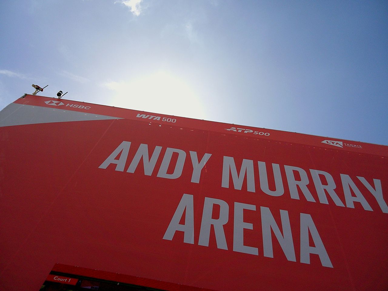 Sample image taken with Camp Snap 2 digital compact camera, showing red front of Andy Murray Arena, strongly backlit by midday sun