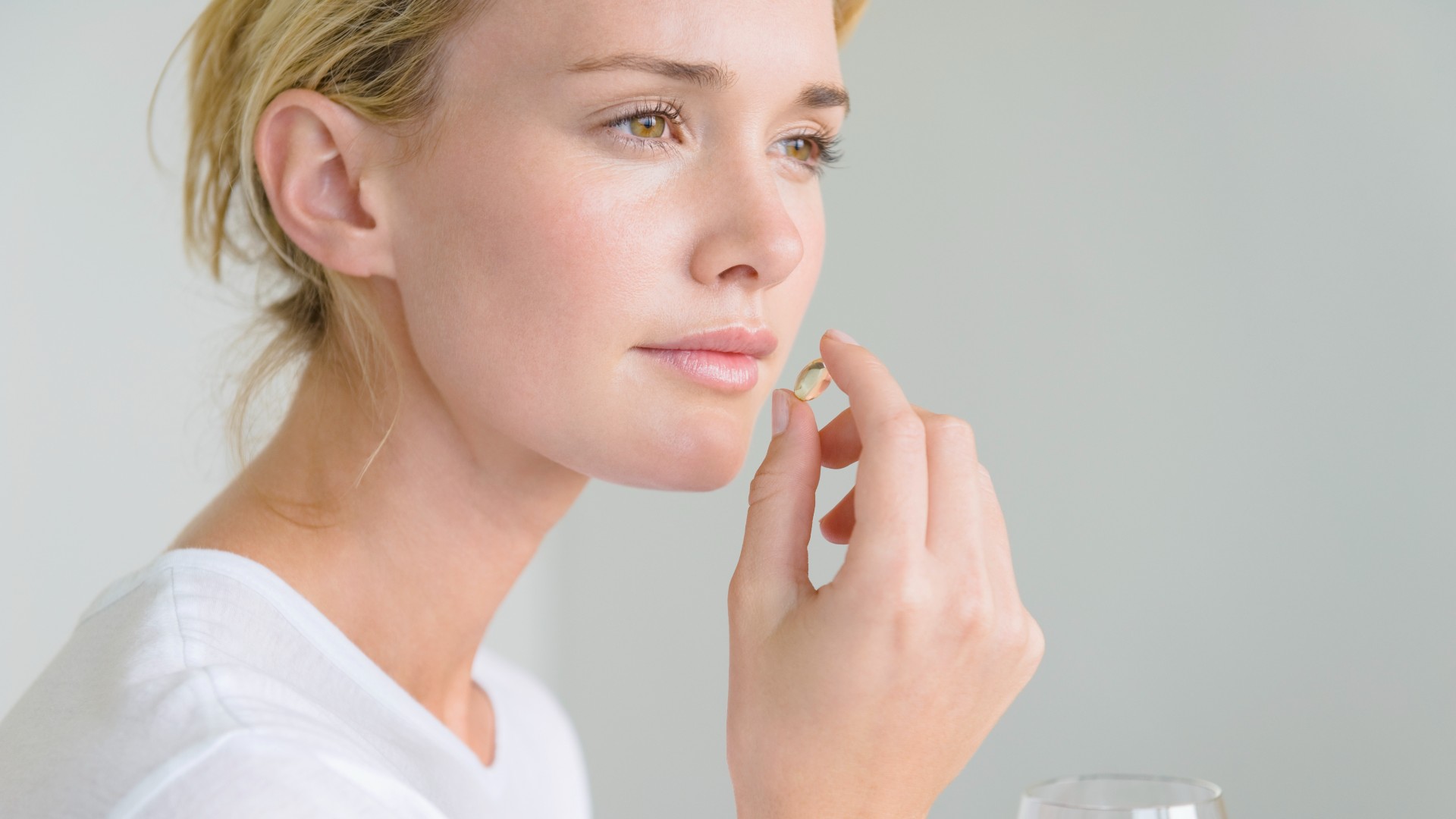 Woman taking fish oil tablets