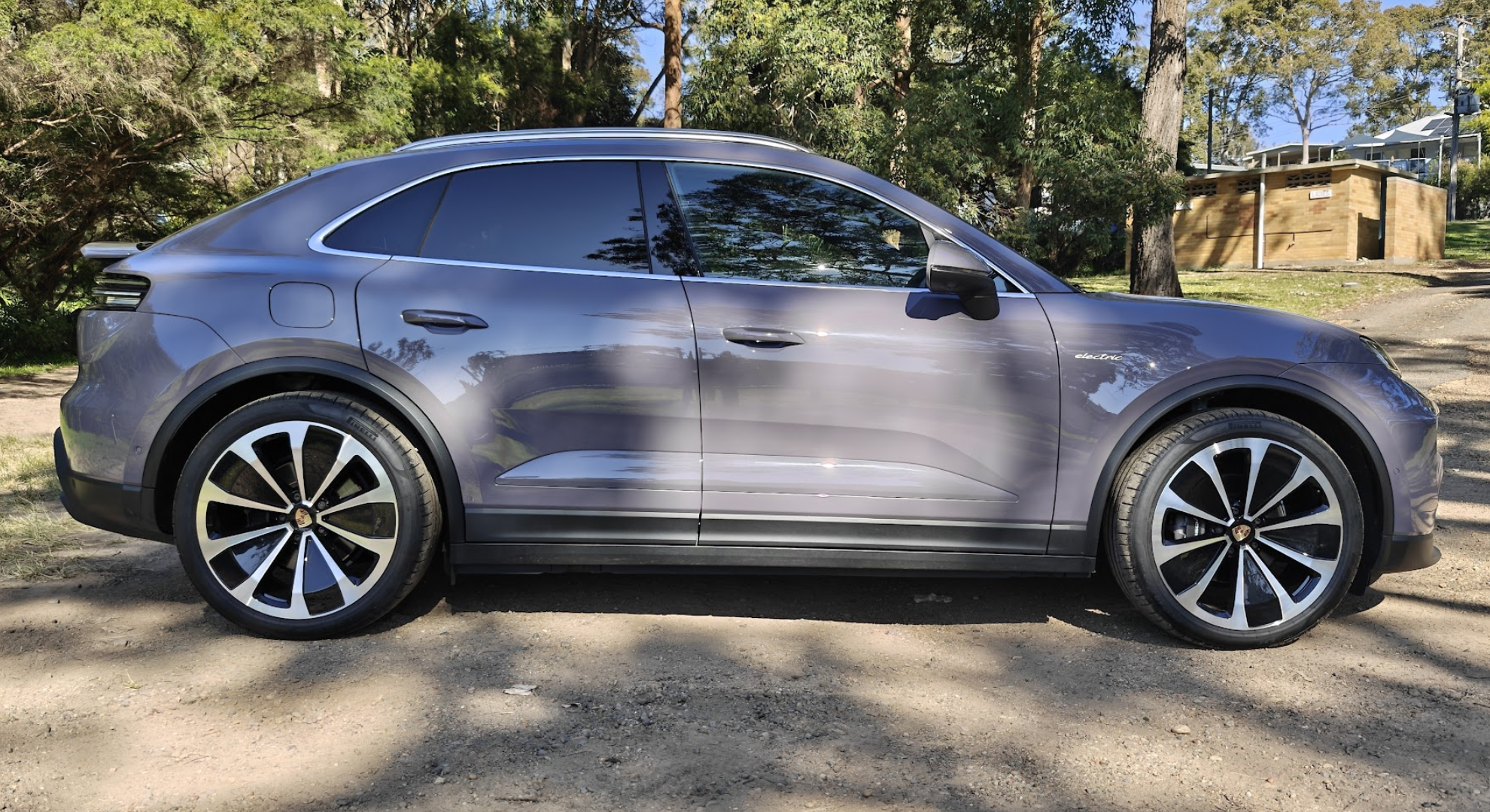 A Porsche Macan EV parked from the side