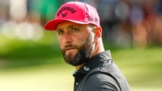 Jon Rahm wearning a pink Callaway cap and a black LIV Golf polo shirt during a tournament