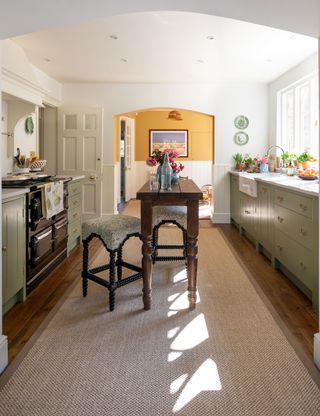 Galley kitchen with rug and wood cabinetry