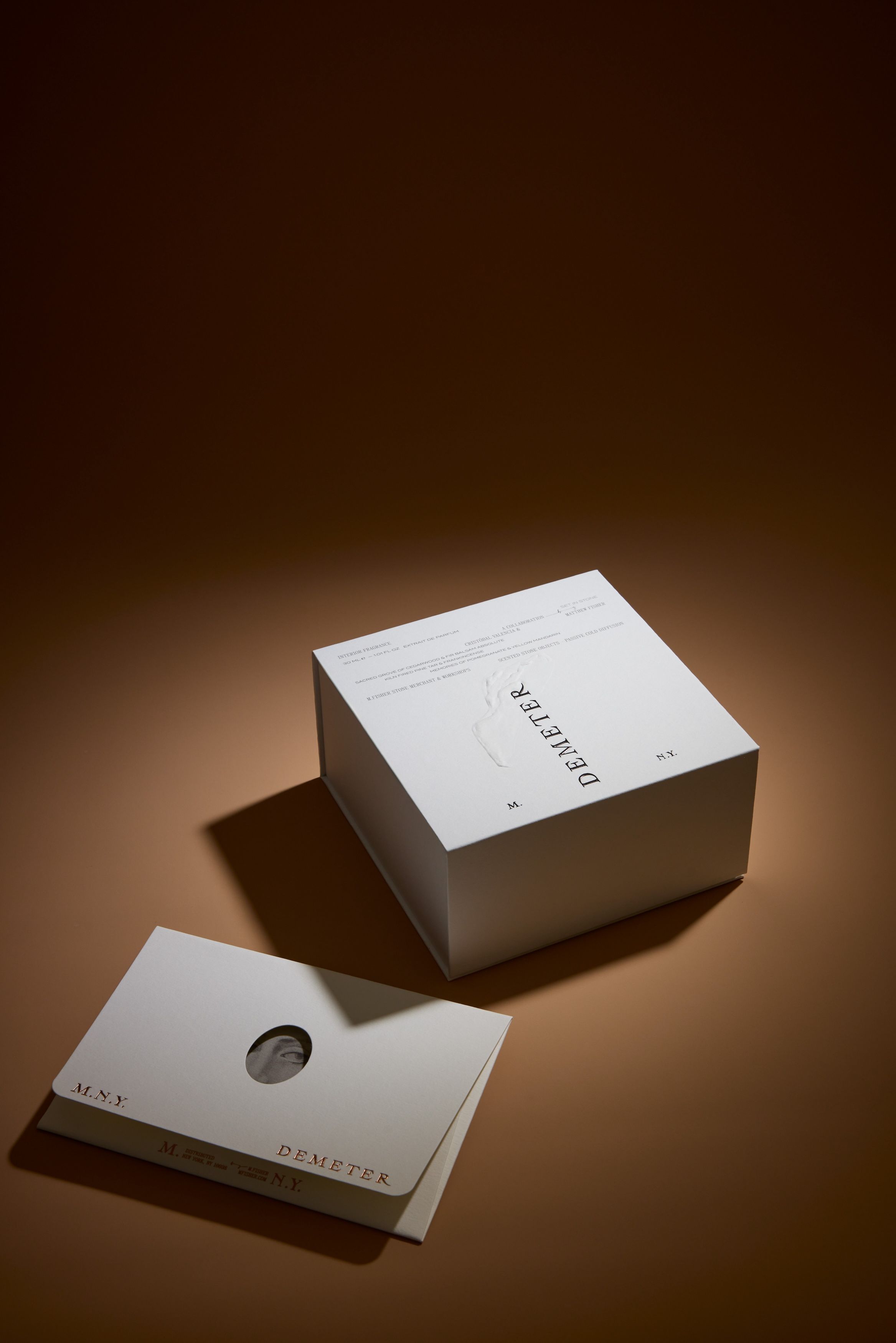 A white box and a white card on top of a tan table.