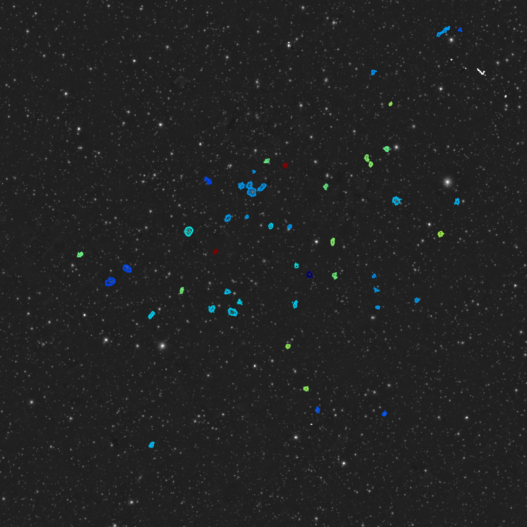 a view of a patch of space, with dozens of distant newfound galaxies circled in blue and green.