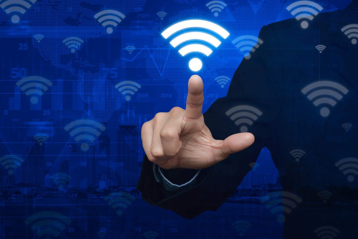 Wireless symbols on blue background as man touches screen