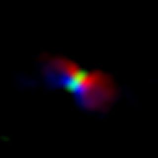 This image from ALMA data shows the rotation of the gas ejecting from the protostar Orion KL Source I. Red marks gas moving away from us, and blue indicates gas moving toward us. The disk of gas surrounding the protostar is in green.