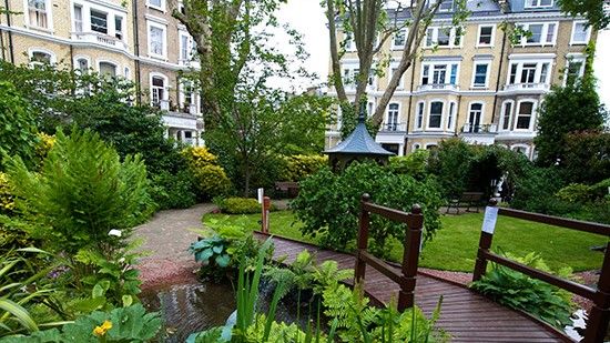 garden with wooden bridge and buildings