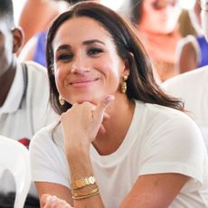 Meghan Markle wears a white T-shirt and gold jewelry