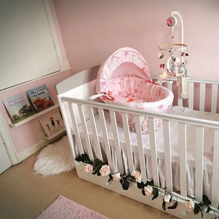 room with pink walls white cot bed and shelves on wall