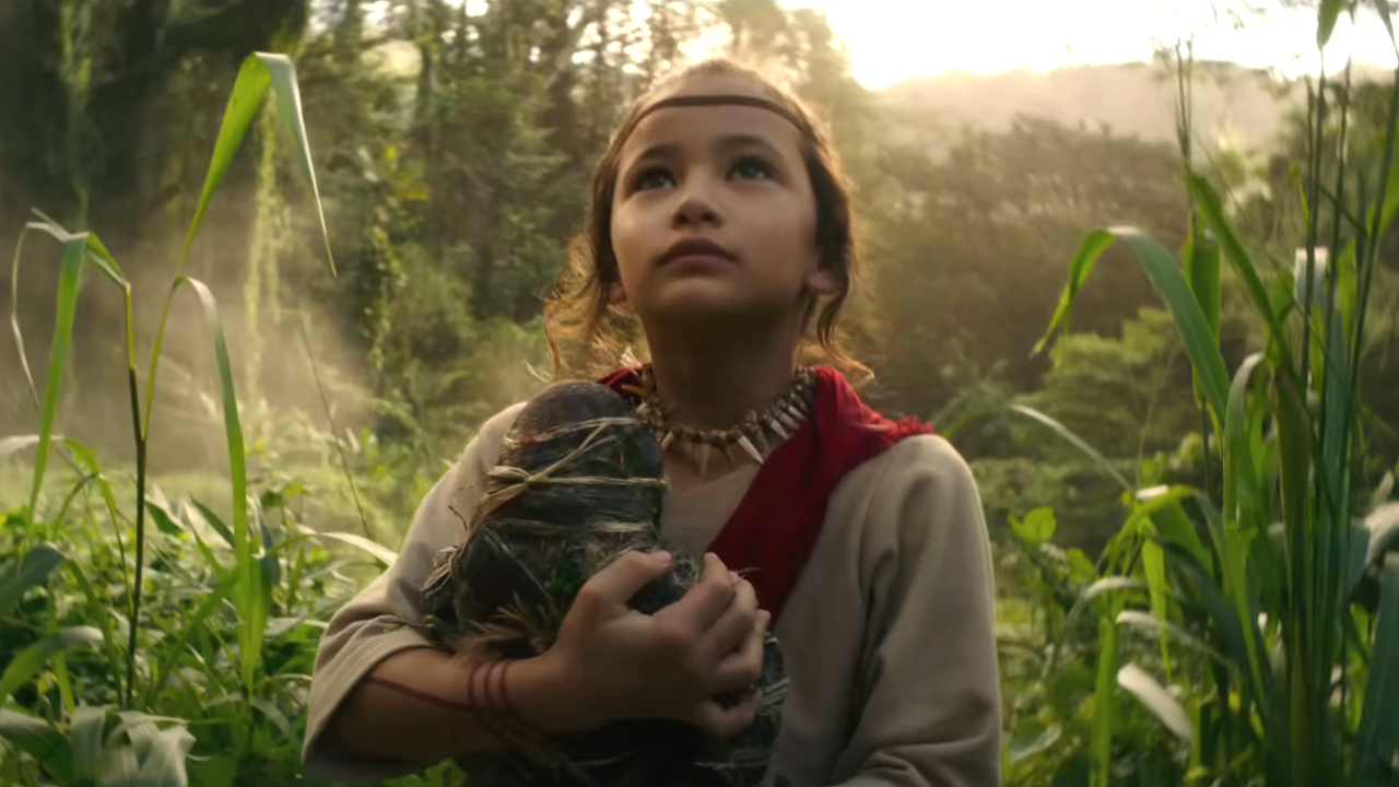 Kaylee Hottle holds a Kong doll in the jungle in Godzilla vs. Kong.