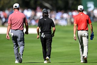 Jon Rahm (left), Angel Hidalgo (centre), and David Puig walk away from camera at the 2024 Open de Espana