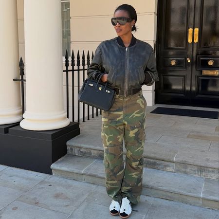 Influencer wearing a leather bomber jacket, camo pants, and sneakers