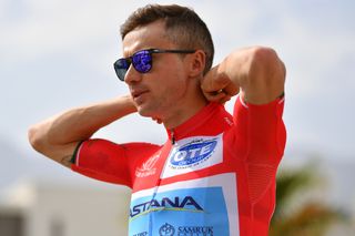 Alexey Lutsenko puts his red jersey on ahead of the stage