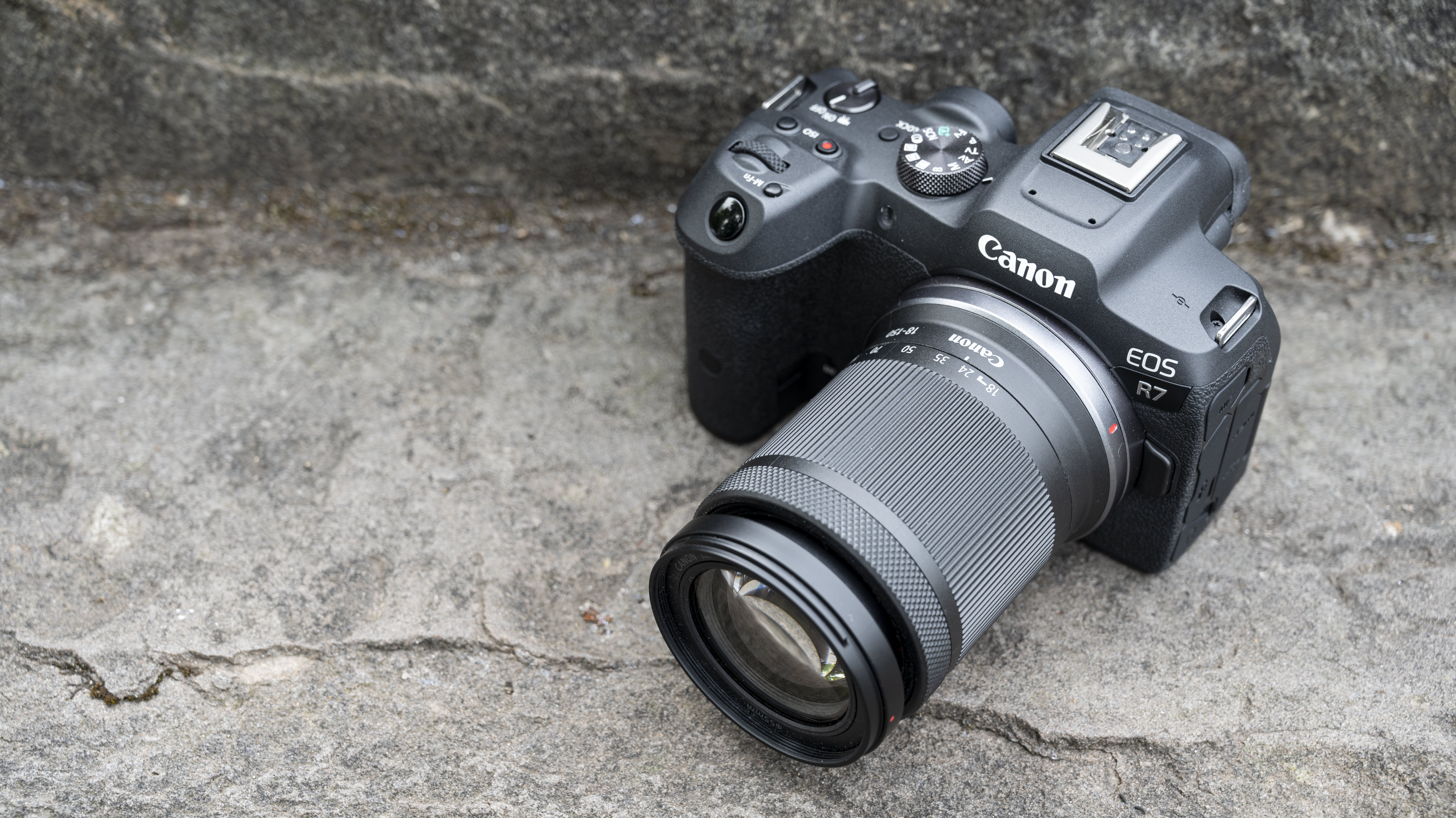 The Canon EOS R7 camera sitting on a stone step