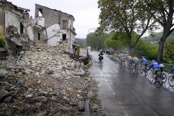 The Giro passes earthquake damaged buildings in L'Aquila