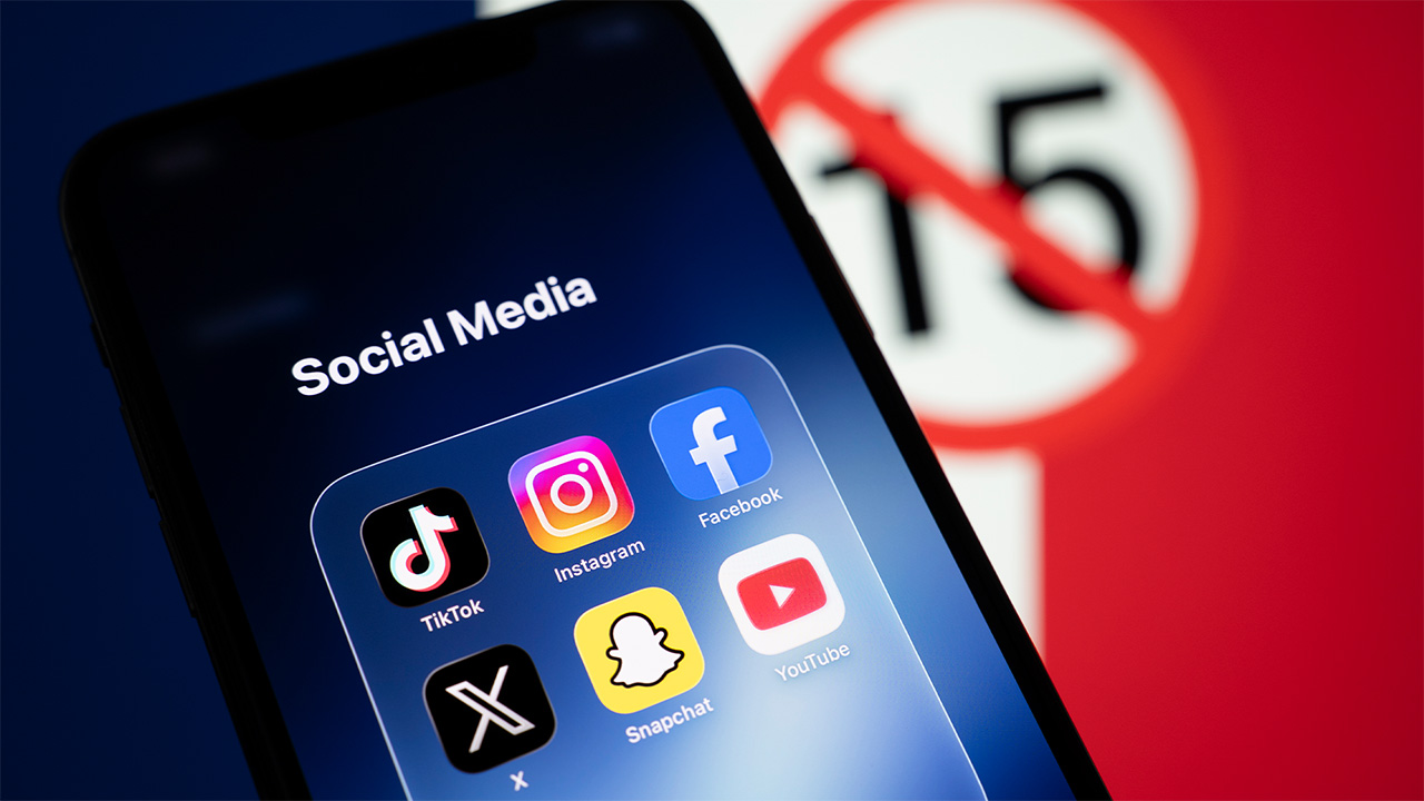 iPhone screen displaying six social media apps in front of a French flag with the number 15 crossed out in a red circle