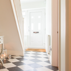 hallway with white wall and white front door