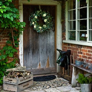 doorway with wreath and firewood