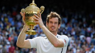 Andy Murray of Great Britain celebrates with the winner's trophy after beating Milos Raonic